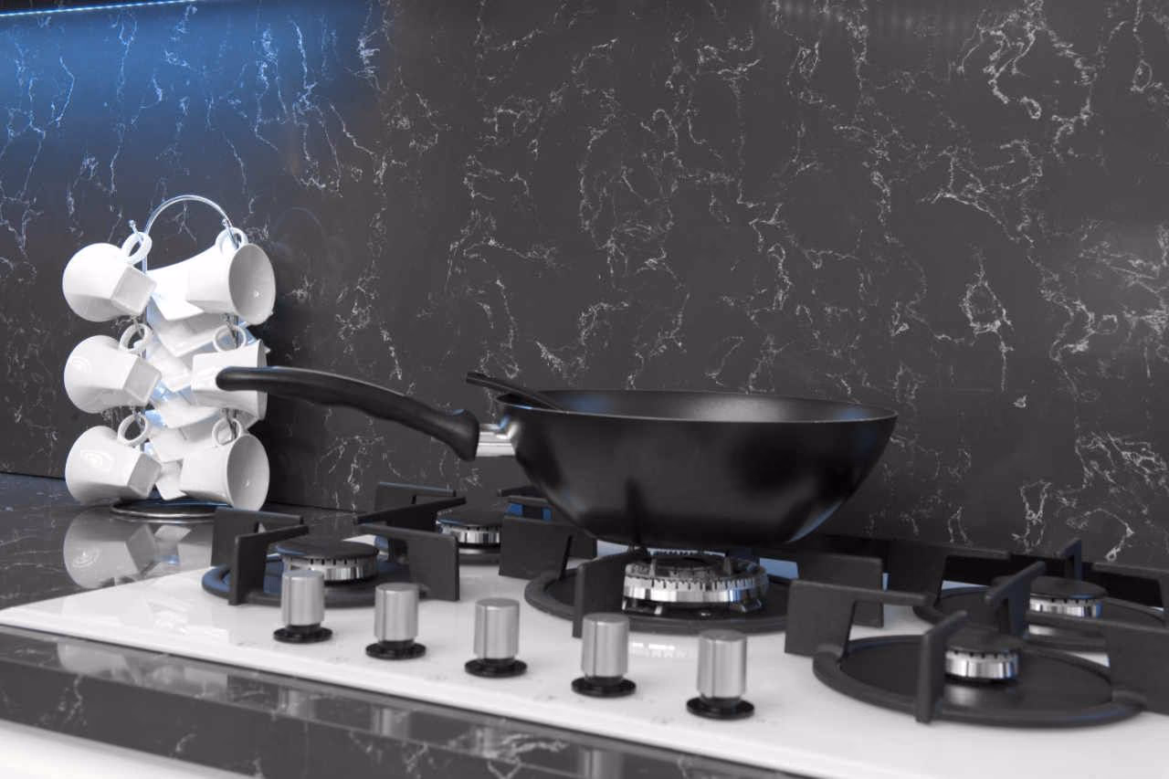 Close-up of a dark Belenco worktop with a hob and pans
